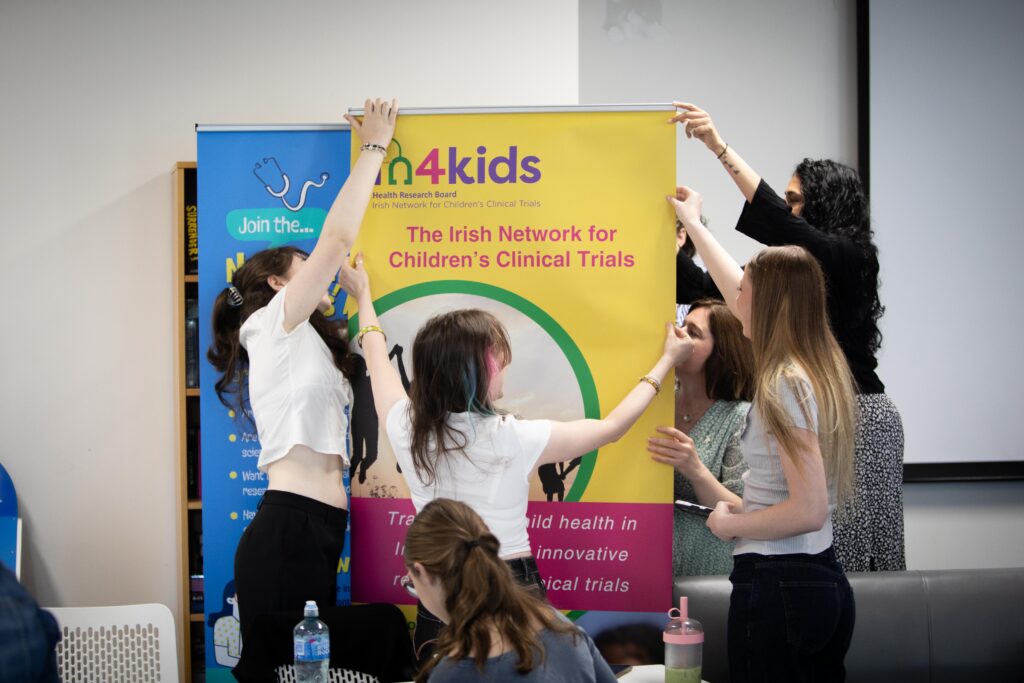 Group of adolescent girls putting up poster